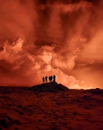 Local resident watch smoke billow as the lava colour the night sky orange from an volcanic eruption on the Reykjanes peninsula 3 km north of Grindavik, western Iceland on December 19, 2023. A volcanic eruption began on Monday night in Iceland, south of th