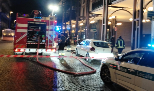 Vigili del fuoco e agenti della polizia locale al lavoro per domare l’incendio scoppiato in via Fratelli D’Italia 