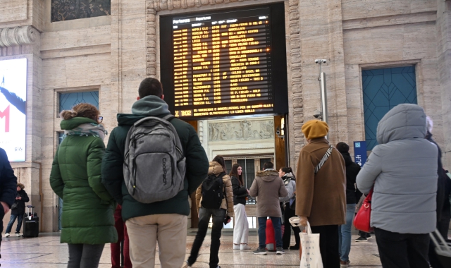 Passeggeri davanti a un tabellone della stazione Centrale di Milano (foto Daniel Dal Zennaro/ANSA)