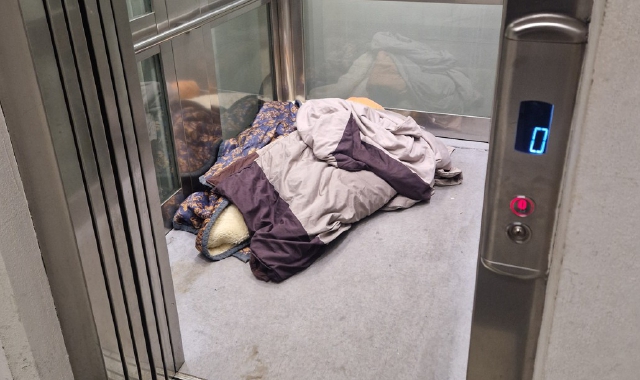 Un clochard che dorme nell’ascensore