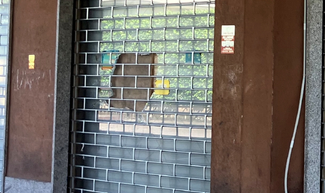 In via Padre Secchi la saracinesca è già stata riparata, ma la vetrata rotta è ancora al suo posto. Il buco aperto nel cristallo è stato tappato con una tavola di legno